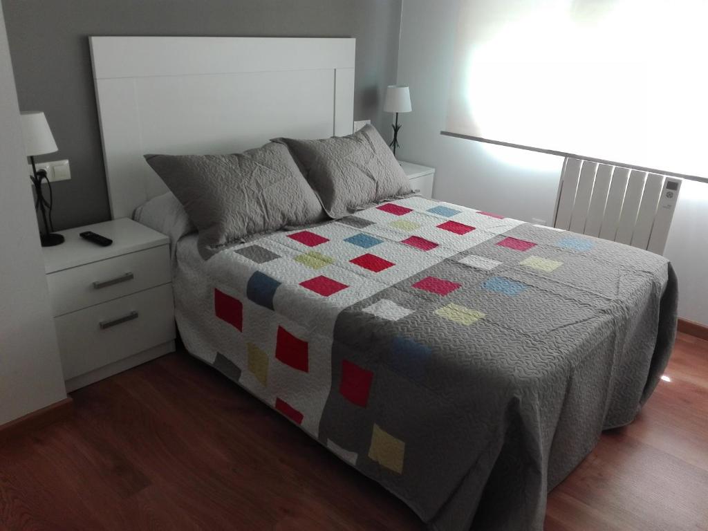 1 dormitorio con 1 cama con edredón en Cancelas 94, en Santiago de Compostela
