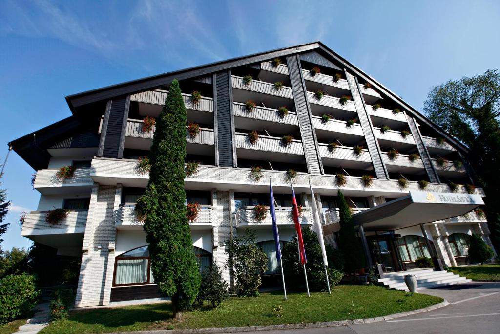 a building with people on the balconies of it at Garni Hotel Savica - Sava Hotels & Resorts in Bled