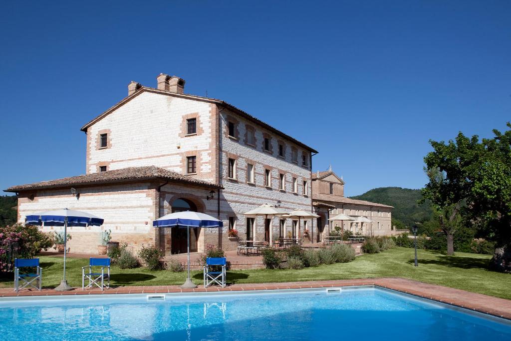an old building with a pool in front of it at Parco Ducale Country House in Urbania