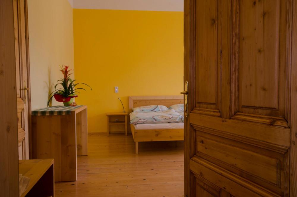 a bedroom with a bed and a yellow wall at Papperl a' Pub in Schonberg am Kamp