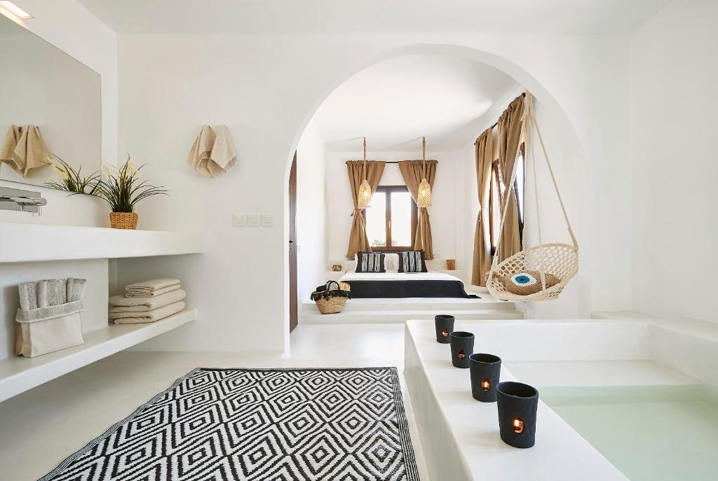 a white room with a bed and a black and white rug at Le Blanc Suite in Mesaria