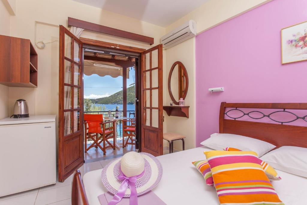 a bedroom with a bed with a view of the ocean at Ionio Sea Poros Studios in Mikros Gialos