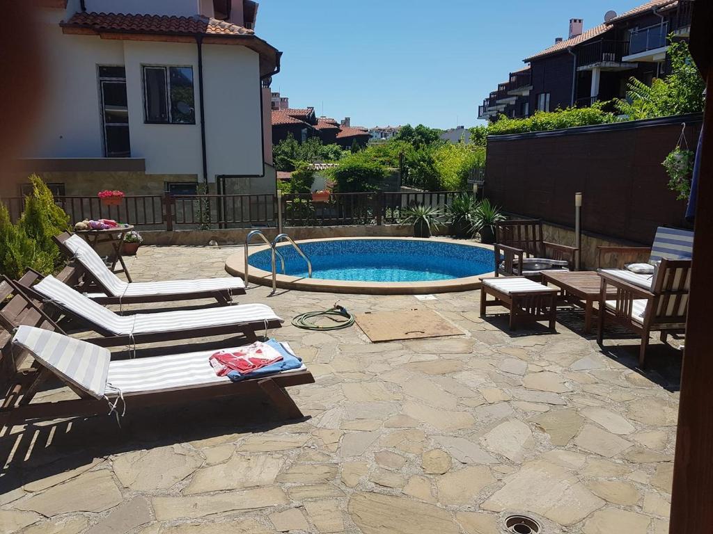 un patio trasero con piscina y tumbonas en Villa Raya, en Sozopol