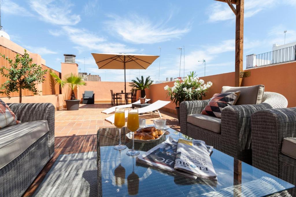 een patio met banken en een tafel op een dak bij Luxury Rooftop - Space Maison Apartments in Sevilla