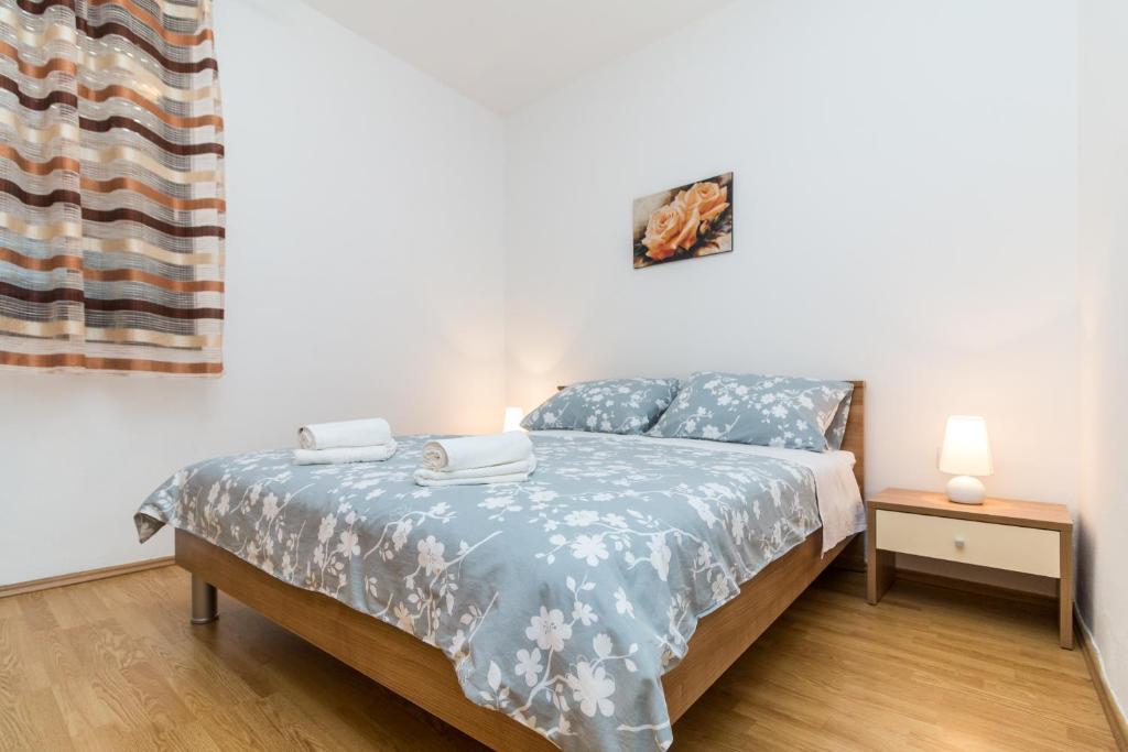 a bedroom with a bed with a blue comforter at Apartment Red Rose in Kaštela