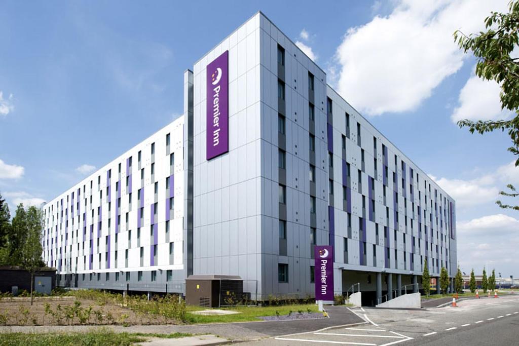 a large white building with a purple sign on it at Premier Inn Heathrow Airport Terminal 4 in Hillingdon