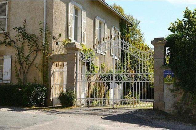une maison avec une porte blanche devant elle dans l'établissement Domaine de la Dame de Laurière, à Solignac