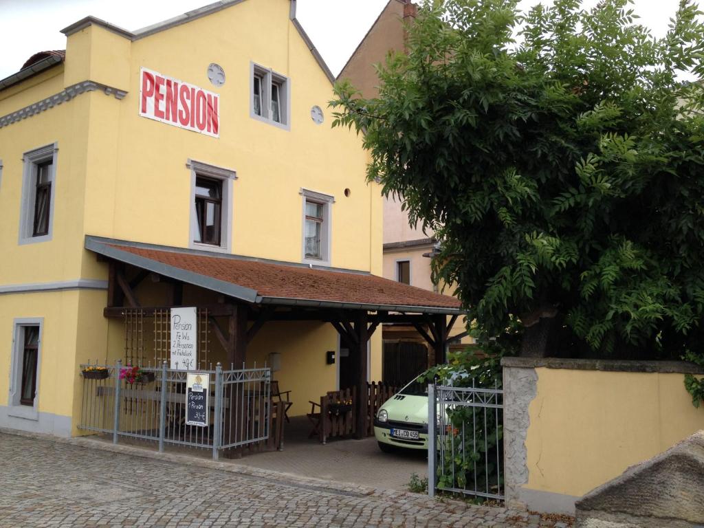 um edifício amarelo com um sinal que lê pistões em Fewo Am Triebischbrunnen em Meissen