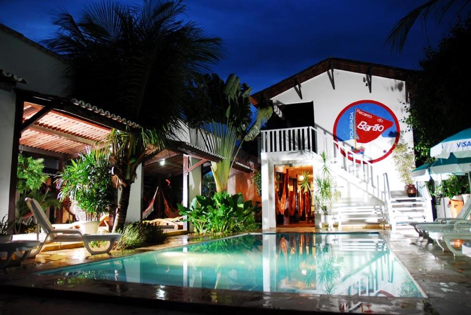 um hotel com piscina em frente a um edifício em Recanto do Barao Pousada em Jericoacoara