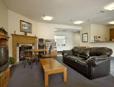 a living room with a leather couch and a table at Days Inn by Wyndham Warsaw in Warsaw