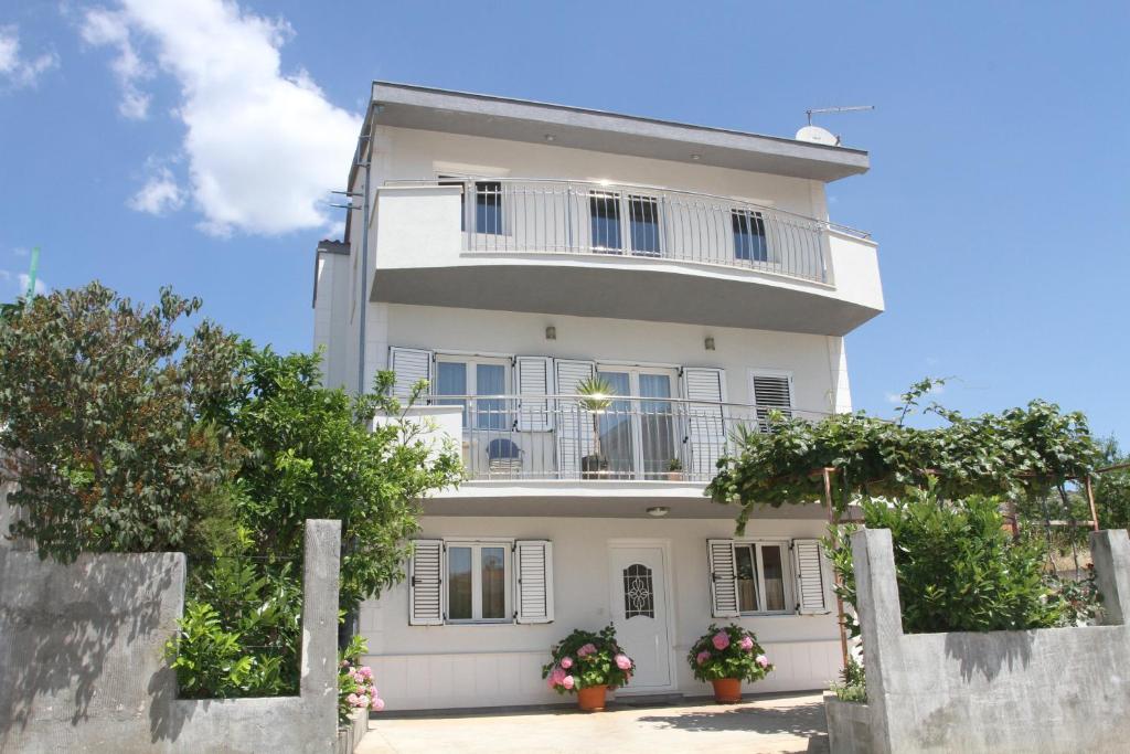 特羅吉爾的住宿－Apartman Karić，白色的房子,上面设有阳台