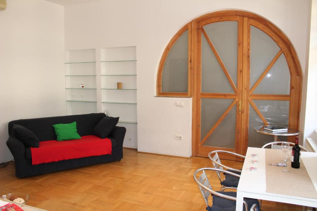 ブダペストにあるKiona Apartmentのリビングルーム(黒いソファ、緑の枕付)