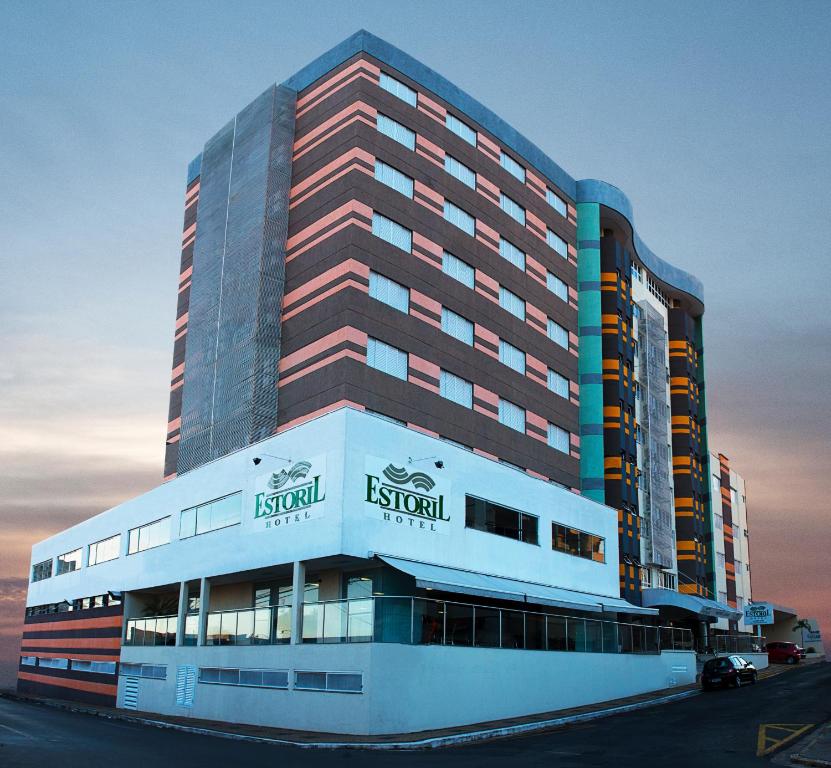 a tall building with a sign on the front of it at Estoril Hotel in Marília