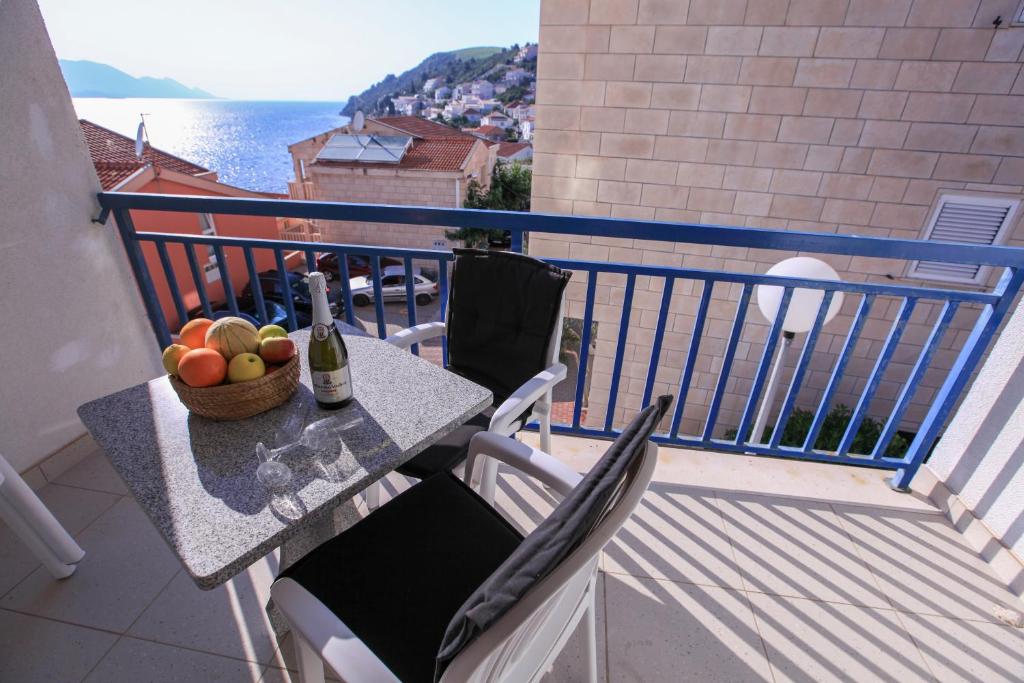 einen Balkon mit einem Tisch und einer Obstschale in der Unterkunft Apartments Gabrijela - Villa Komarna in Klek