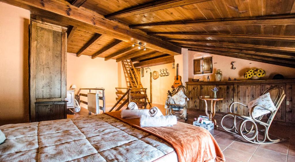 Un dormitorio con una cama grande en una habitación con techos de madera. en Casa La Herradura en Royuela