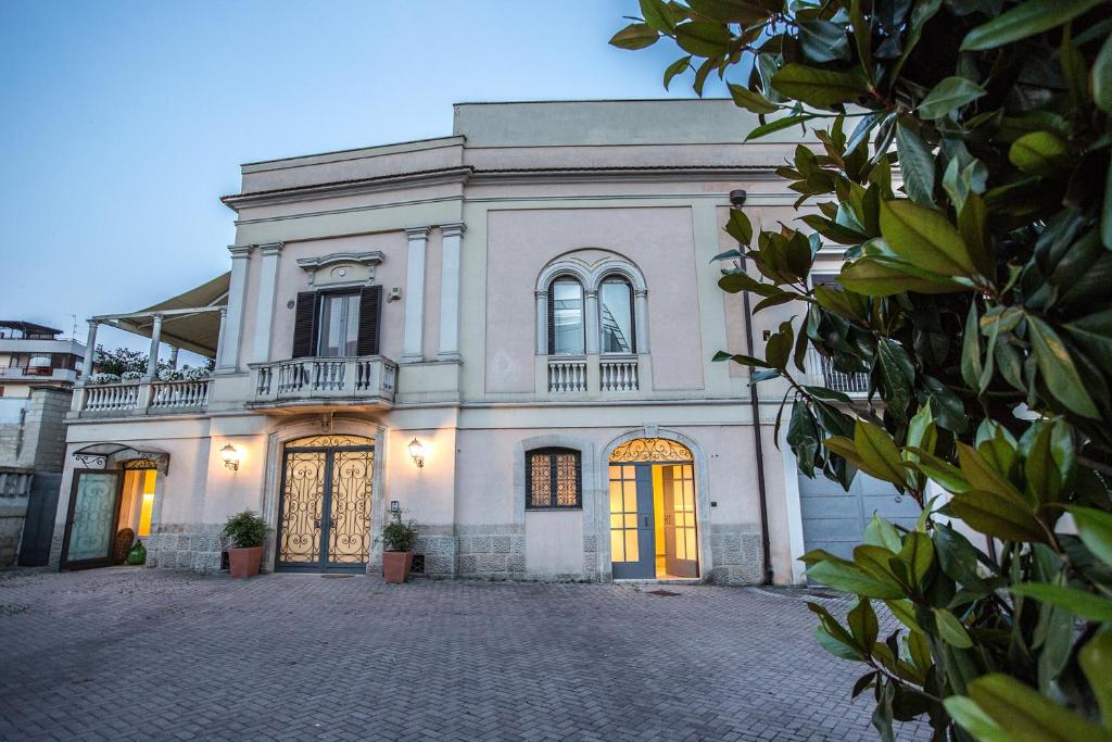 una gran casa blanca con una entrada delante de ella en Giardini 82 B&B, en Gravina in Puglia