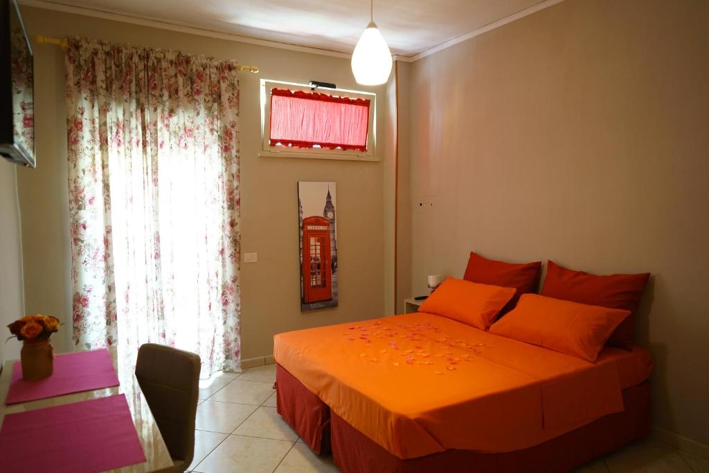 ナポリにあるWelcome Inn Napoliのベッドルーム1室(オレンジのシーツが入ったベッド1台、窓付)