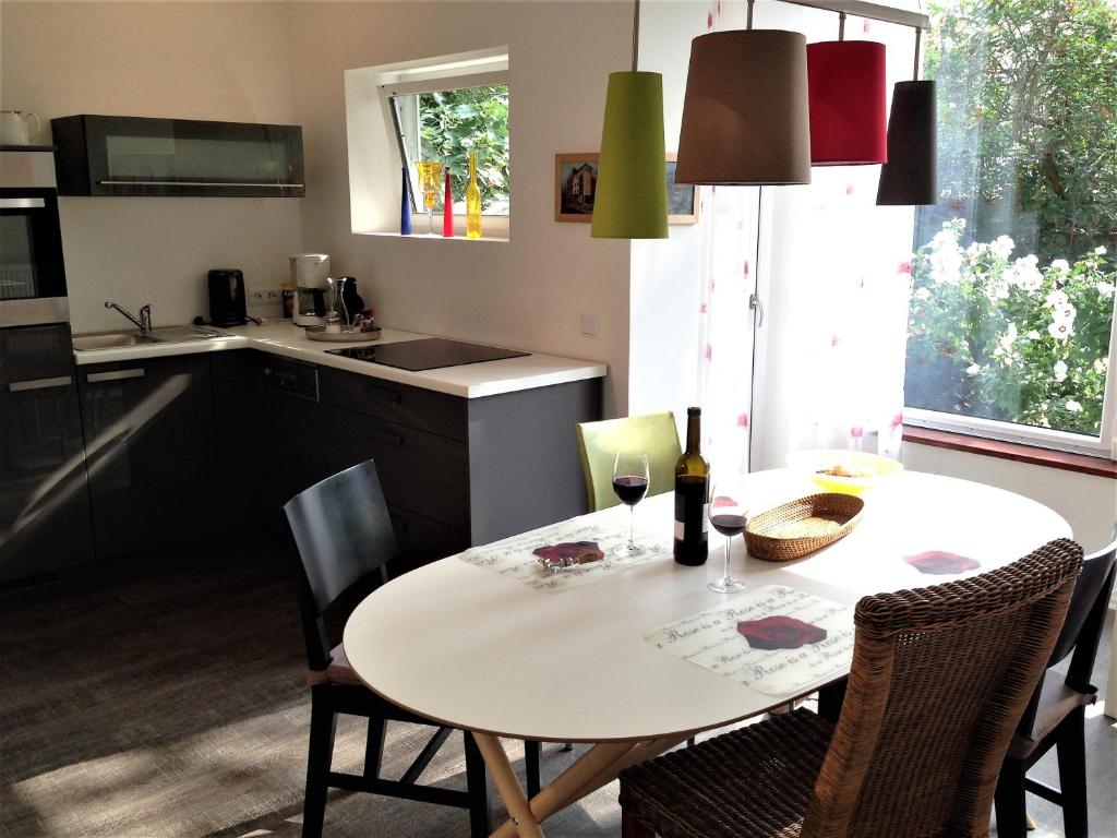 a kitchen with a white table and chairs and a table and a kitchen with at Stadtoase Koblenz in Koblenz