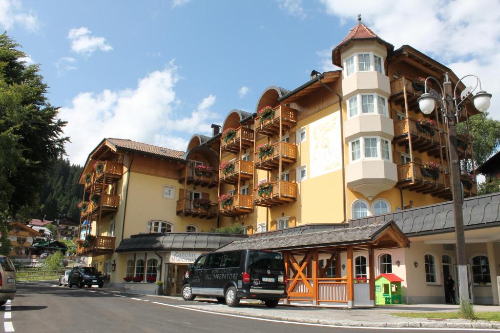 une camionnette garée devant un grand bâtiment dans l'établissement Hotel Chalet all'Imperatore, à Madonna di Campiglio