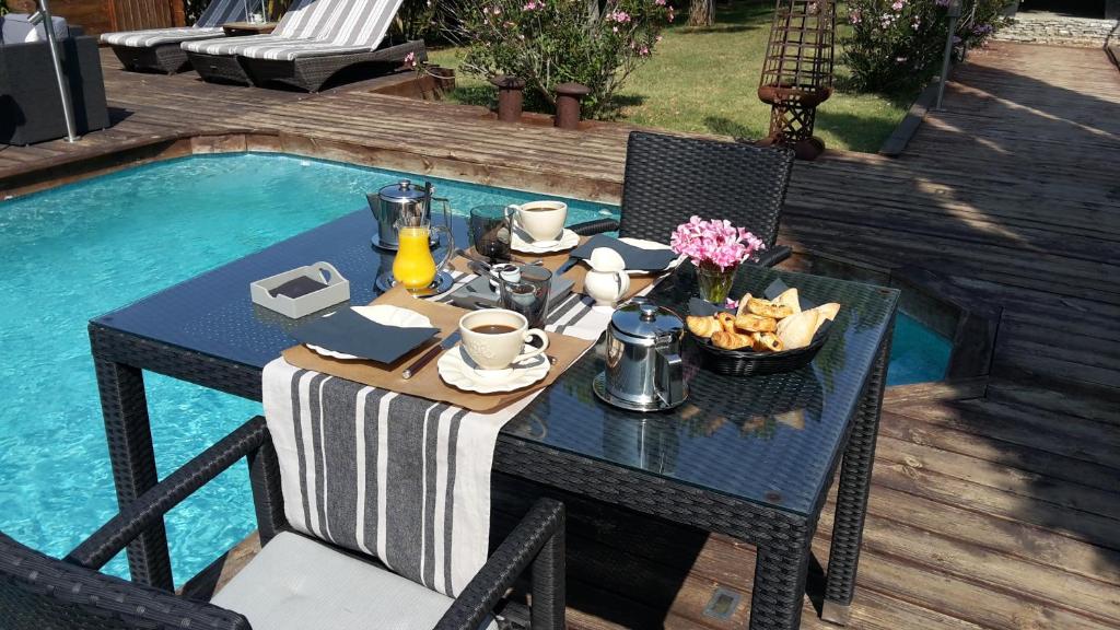 una mesa con un tazón de comida junto a una piscina en Les Chambres d'Hôtes de la Ferrage, en La Tour-dʼAigues