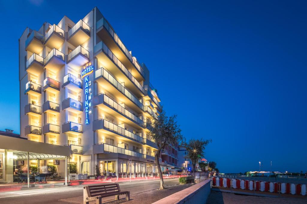 un bâtiment avec un banc devant lui dans l'établissement Hotel Karinzia, à Caorle