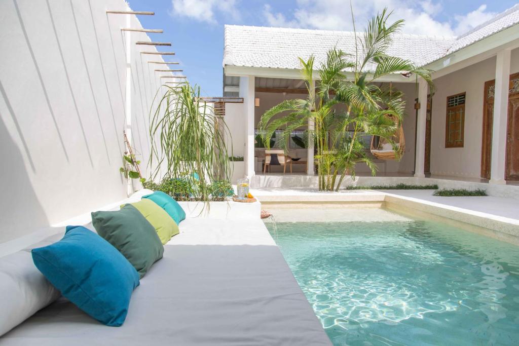 a pool with pillows next to a house at Villa Azcoyen Bali in Canggu