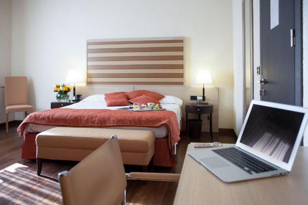 um quarto de hotel com uma cama e um computador portátil numa secretária em La Bettola em Carisio
