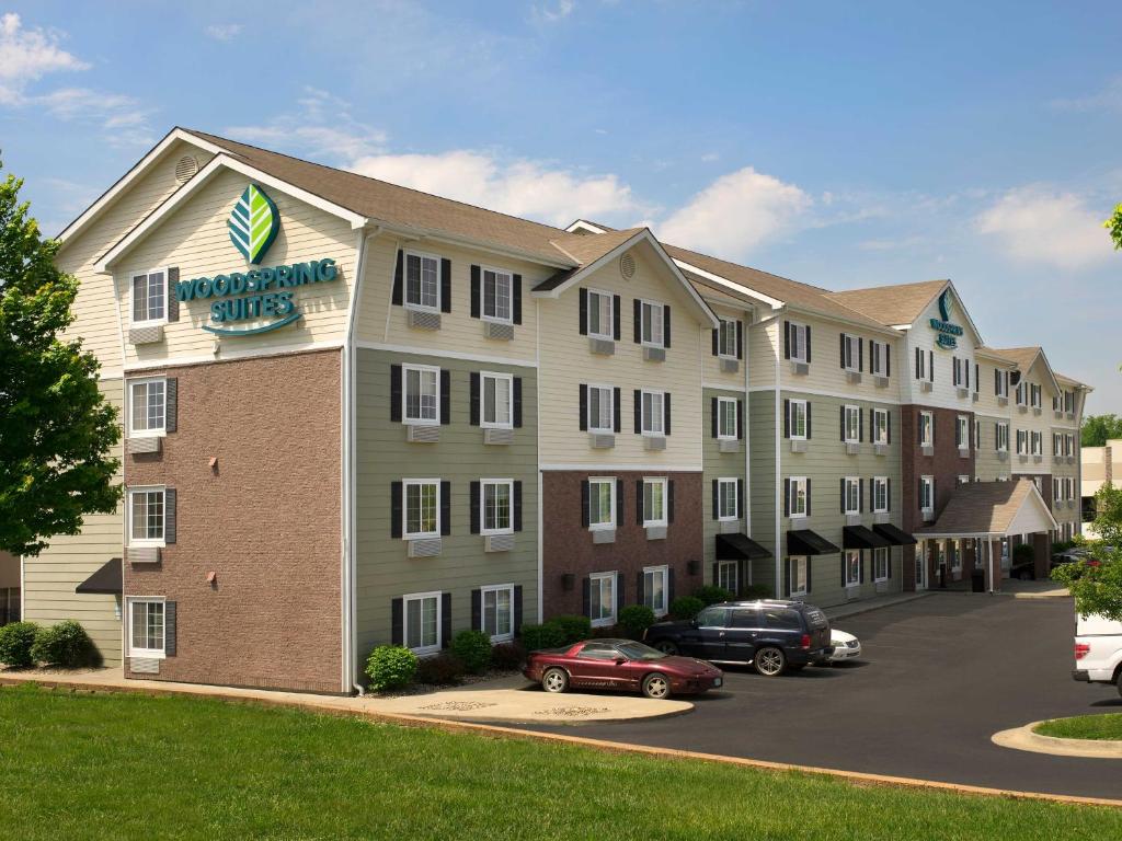 a hotel with cars parked in a parking lot at WoodSpring Suites Kansas City Liberty in Liberty