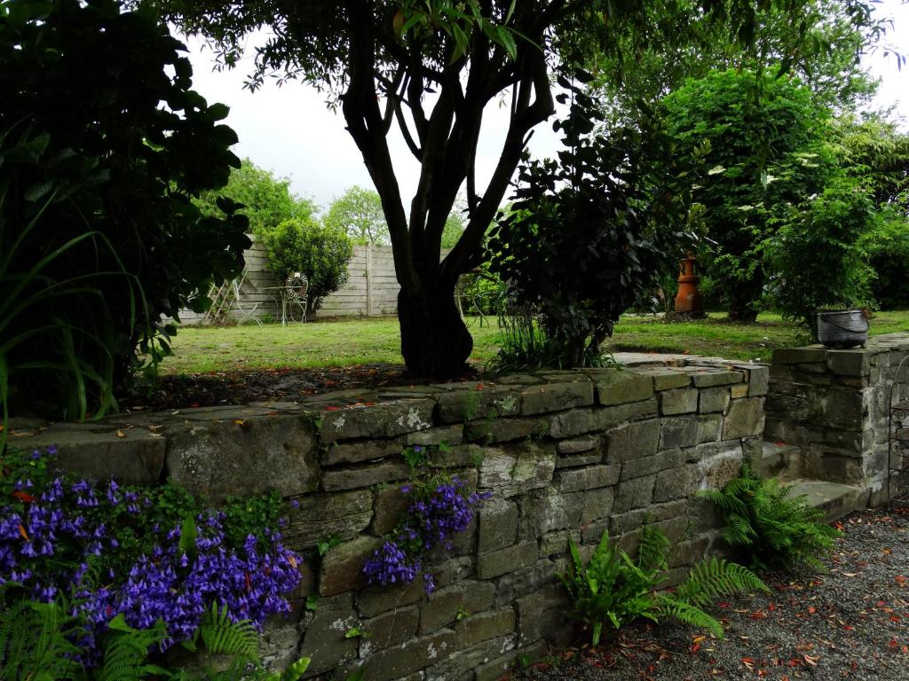 a stone retaining wall with a tree in the background at Le Relais in Saint-Sauveur-la-Pommeraye