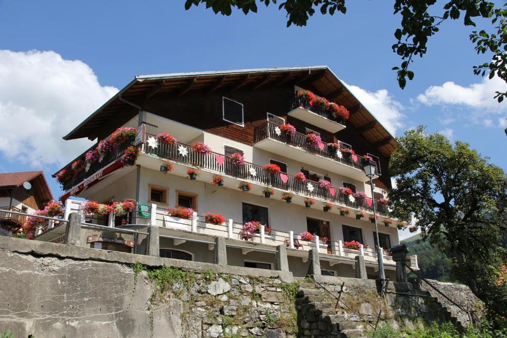 a building with flowers on the balconies of it at Relais Du Charvin in Le Bouchet-Mont Charvin