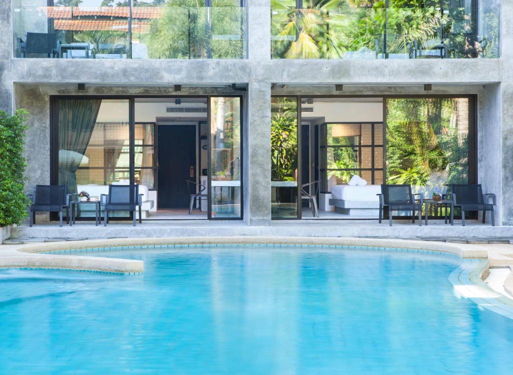 a swimming pool in front of a house at Kokotel Khao Lak Lighthouse in Khao Lak
