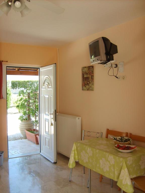 a dining room with a table and a tv on the wall at Gouna's Aparts in Xi