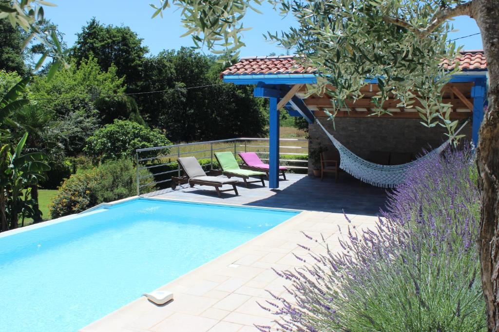 a swimming pool in a garden with a gazebo at Chambre d'Hôtes au Sargaillon in Pouillon