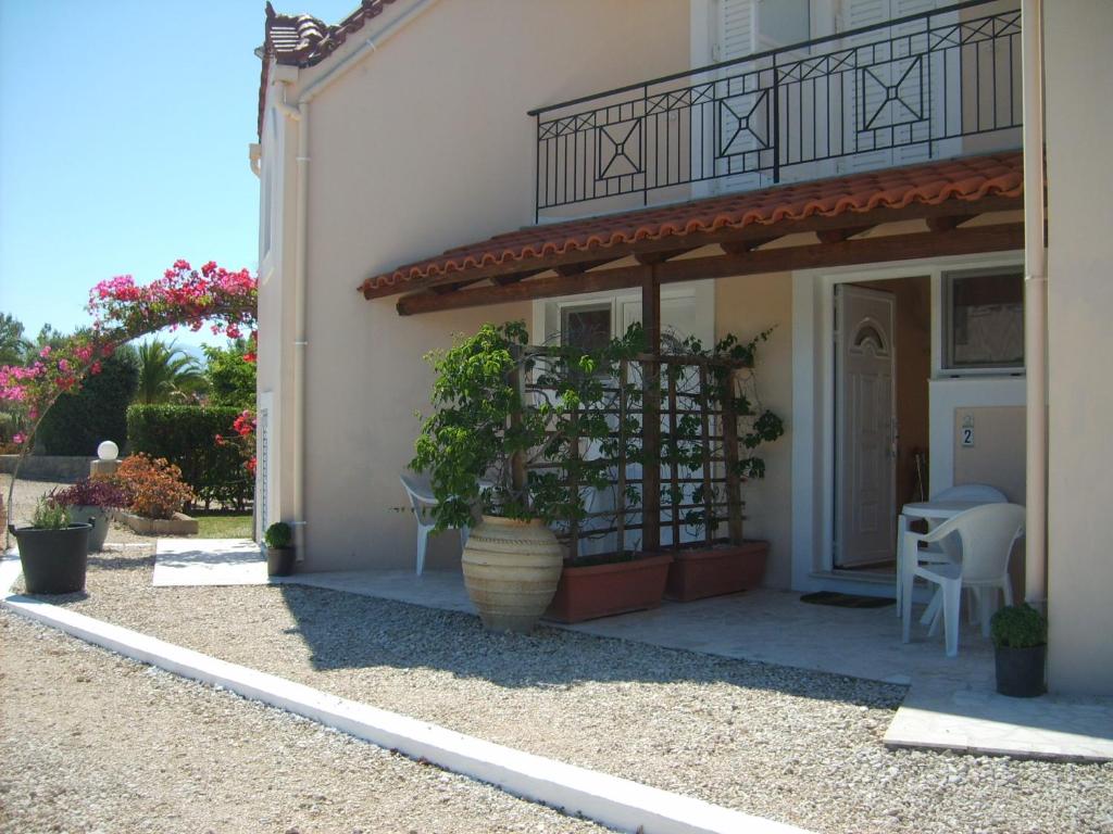 a house with a porch with a potted plant at Gouna's Aparts in Xi