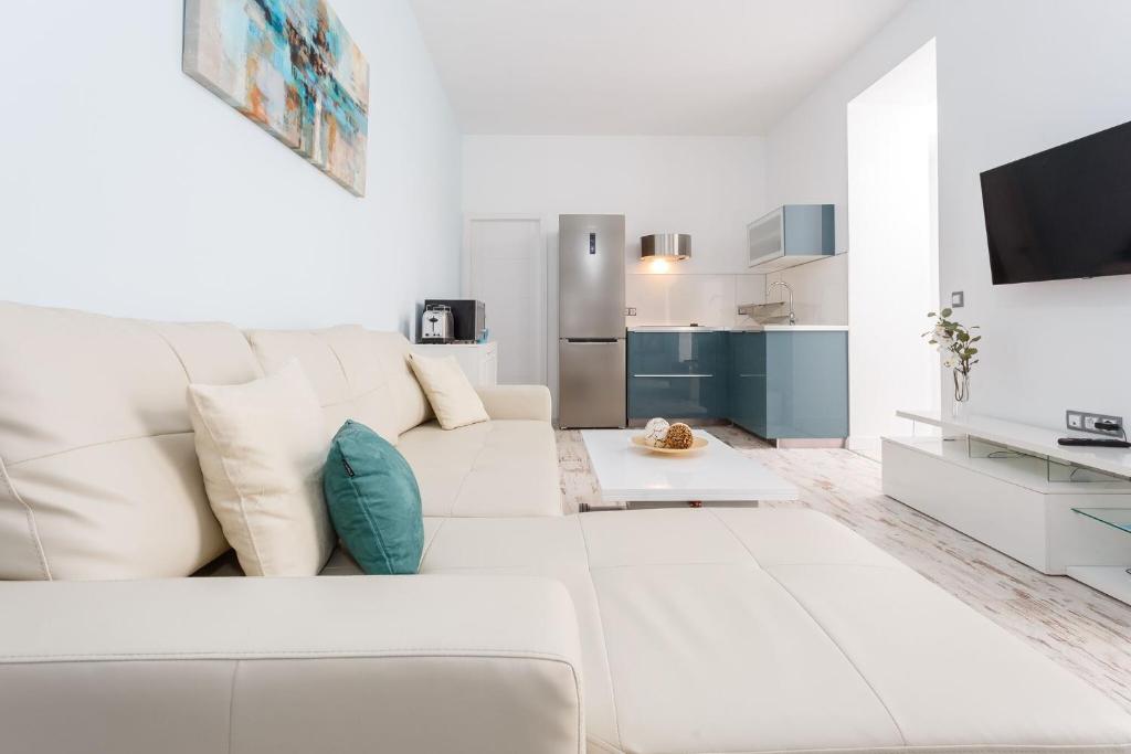 a white living room with a white couch at La Perla de La Caleta in Cádiz