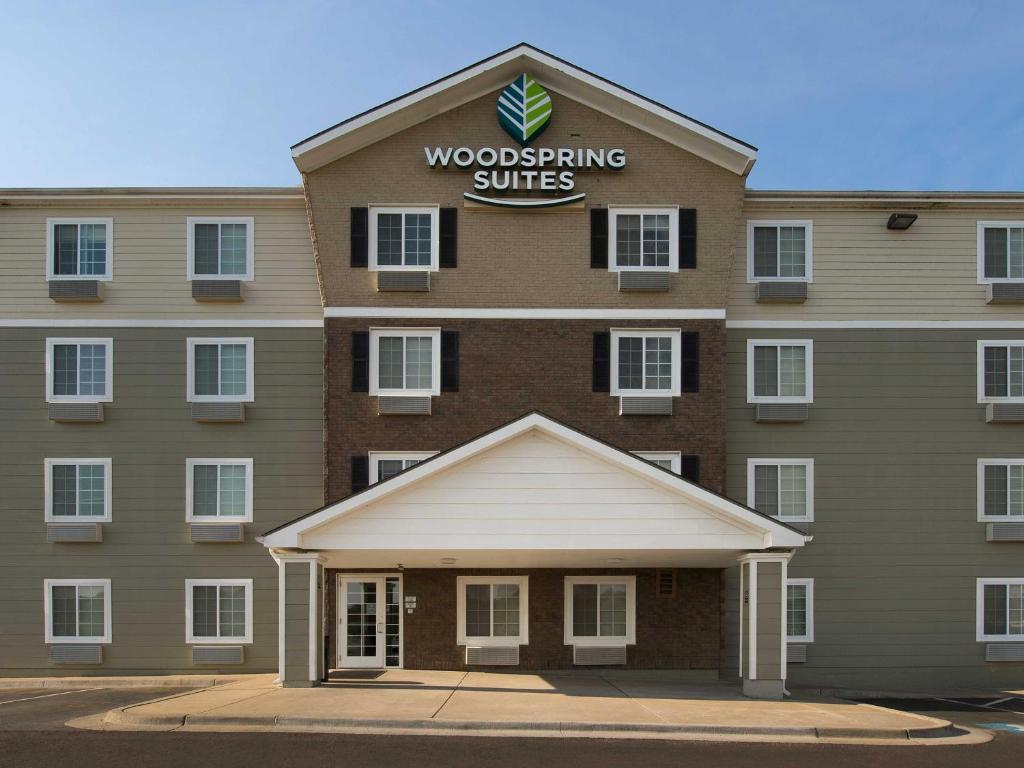 a building with a woodworking suites sign on it at WoodSpring Suites Kansas City Mission in Merriam