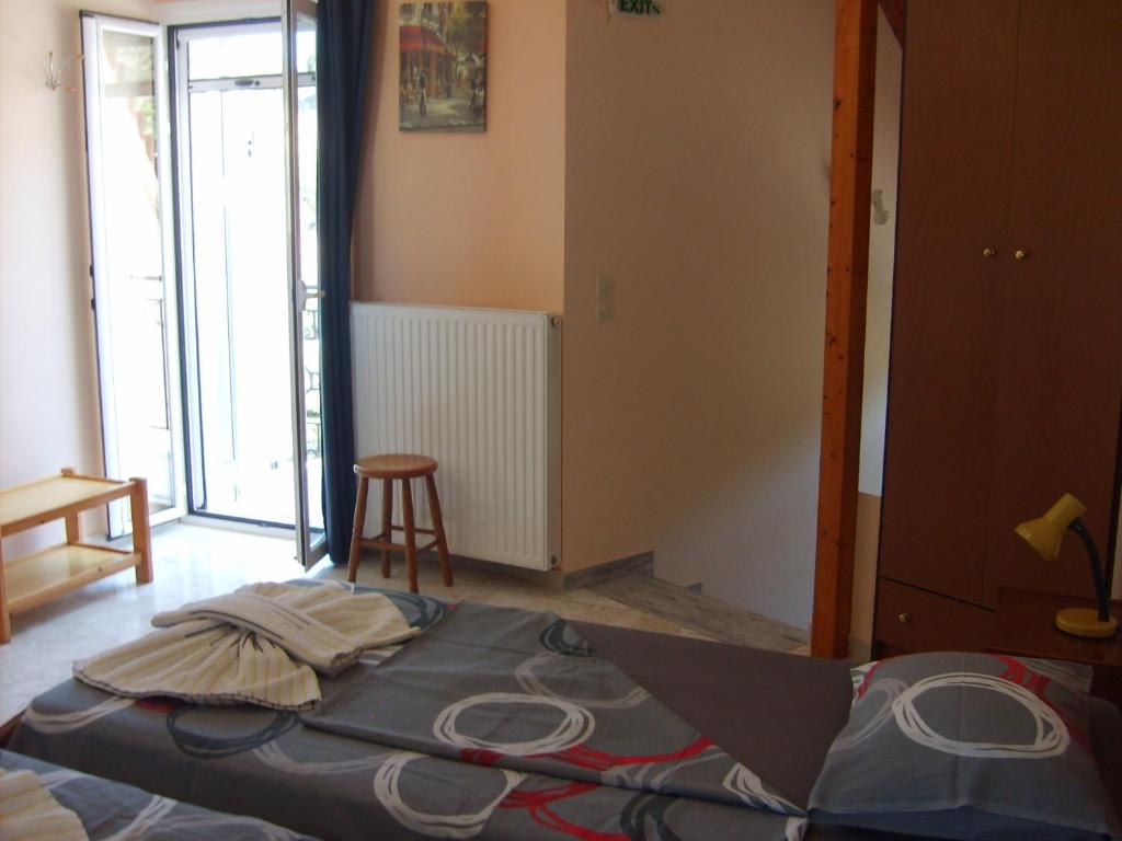 a bedroom with a bed and a stool in a room at Gouna's Aparts in Xi