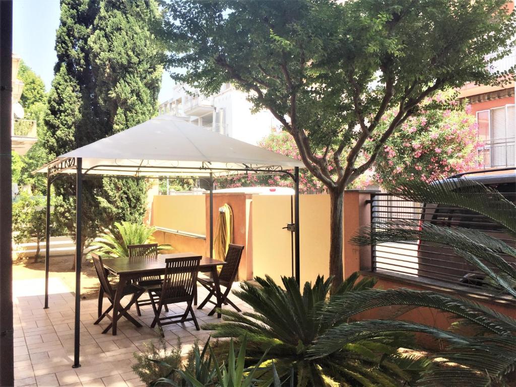 einen Tisch und Stühle unter einem Sonnenschirm auf einer Terrasse in der Unterkunft Miramare Beach Apartment in Rimini