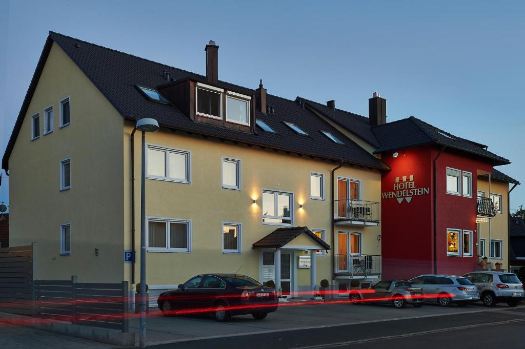 Hotel Wendelstein في فينديلشتآين: مبنى فيه سيارات تقف امامه