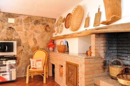 a living room with a fireplace with a stone wall at Mare&relax in Santa Maria Navarrese