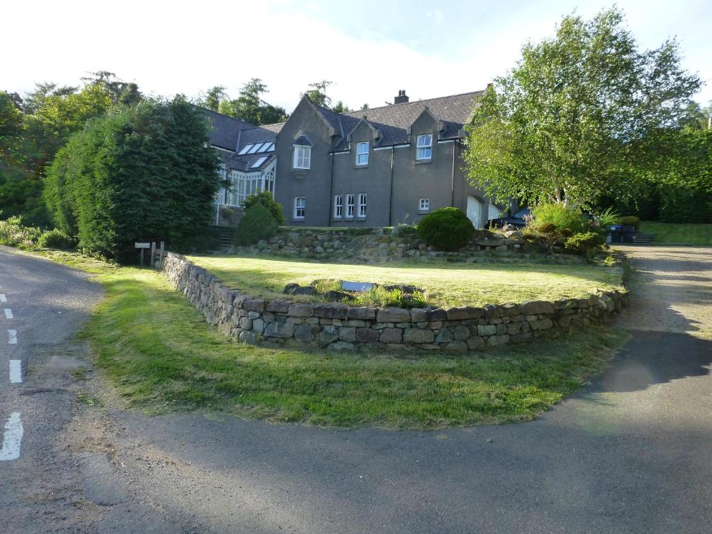 a stone retaining wall in front of a house at Whitehill in Finzean