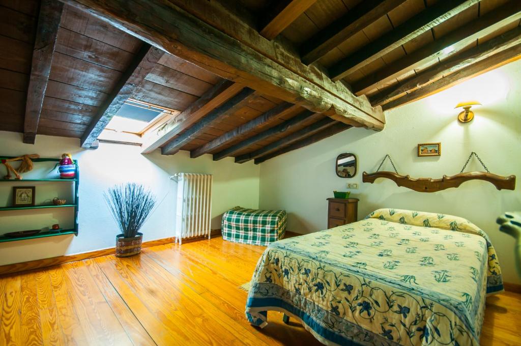 1 dormitorio con 1 cama y suelo de madera en Casa Rural Finca Umbría, en Plasencia