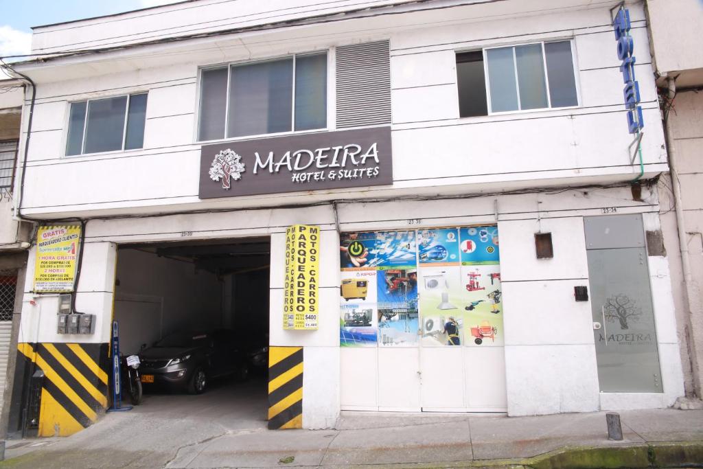 un bâtiment avec un garage avec une voiture dans l'établissement Hotel Madeira, à Manizales