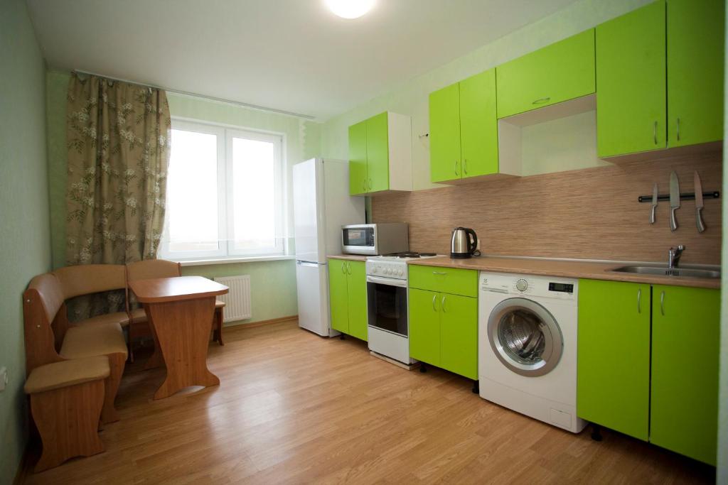 プーシキンにあるАпартаменты на Изборскойのキッチン(緑のキャビネット、洗濯機付)