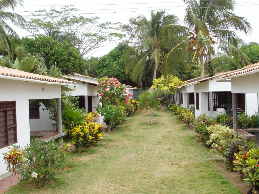 una fila de casas con flores y palmeras en Hostal Roldan, en Coveñas