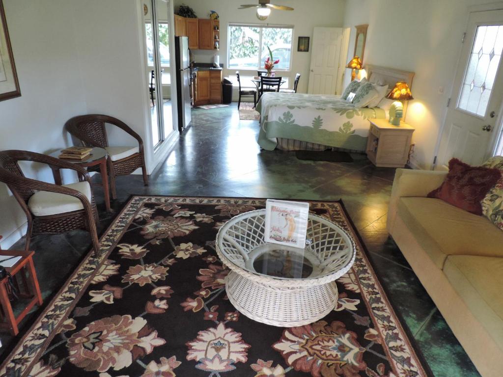 a living room with a couch and a table at Hale Pua Villa - Hibiscus Suite in Koloa