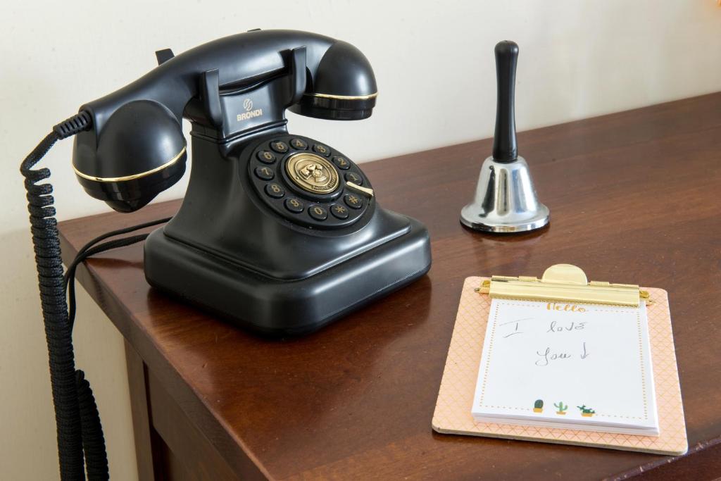 a telephone sitting on a desk with a note at Art de vivre in Sorrento