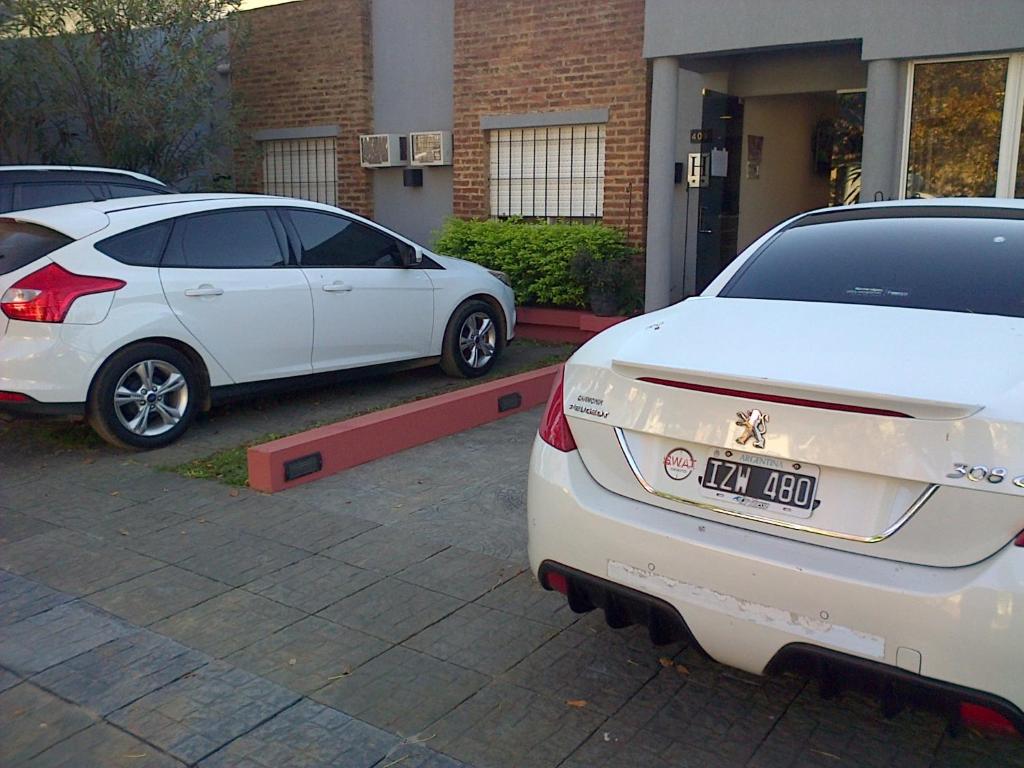 two white cars parked in front of a house at La Posada de Los Fresnos in Colón