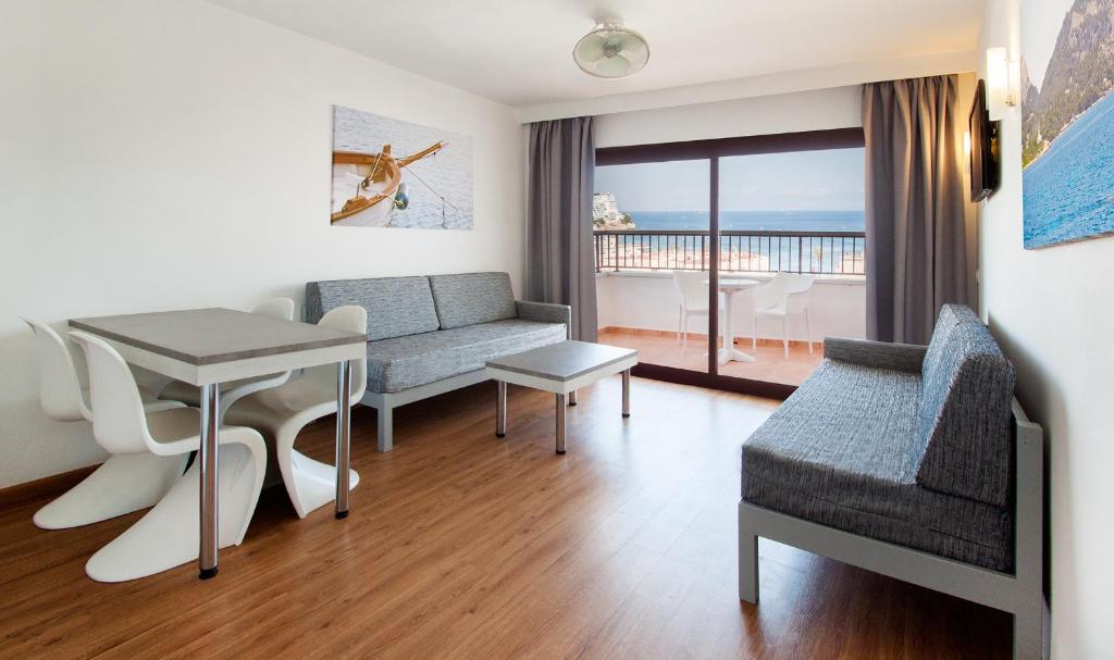 ein Wohnzimmer mit einem Sofa und einem Tisch in der Unterkunft Apartamentos Sol y Vera in Magaluf
