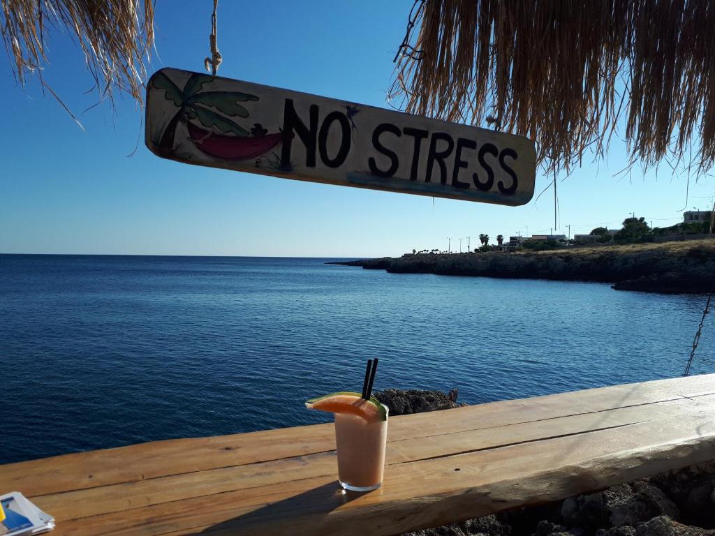 a drink sitting on a table with a no stress sign at Monolocale Santa Caterina in Santa Caterina di Nardò